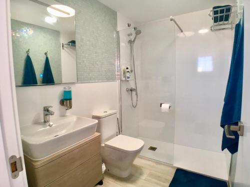 a bathroom with a sink and a toilet and a shower at Casa Solaris at Anfi Beach with Private Terrace, Pool & Netflix in Arguineguín