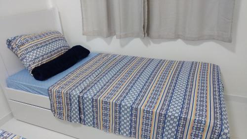 a bed in a bedroom with a blue and white mattress at Condomínio Residencial Tranquilidade na Beira do Rio in Paulo Afonso