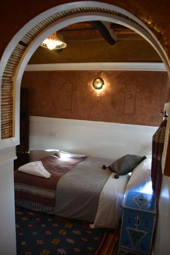 a bedroom with an archway with a bed in it at Kasbah Assafar in Kalaat MGouna