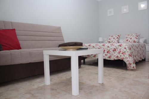 un soggiorno con tavolo bianco e divano di Nice and New Studio very close to the city center a Málaga
