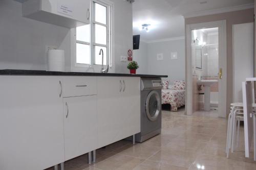 una cucina con lavatrice in camera di Nice and New Studio very close to the city center a Málaga