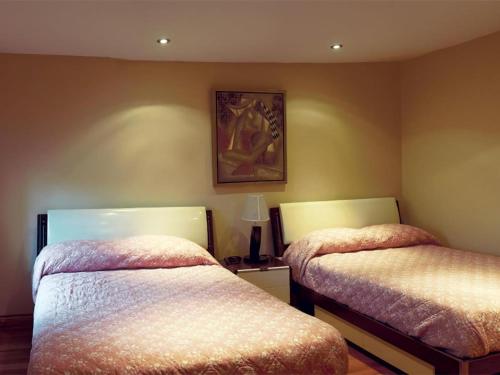 a bedroom with two beds and a picture on the wall at Dragon Gate Inn in Toronto