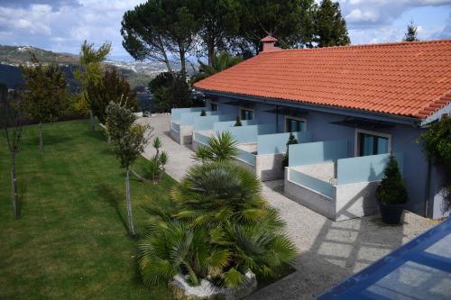 a blue house with a red roof at Casa das Carpas in Vizela