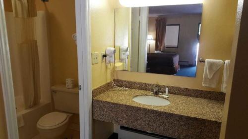 a bathroom with a sink and a toilet and a mirror at Loyalty Inn Rockingham in Rockingham