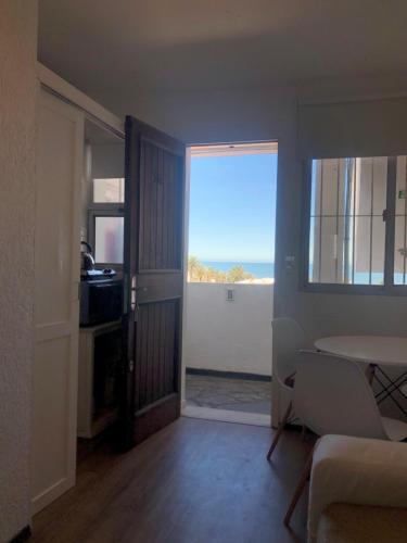 Sala de estar con mesa y vistas al océano en Apartamento 4 Mares - El Faro en Punta del Este