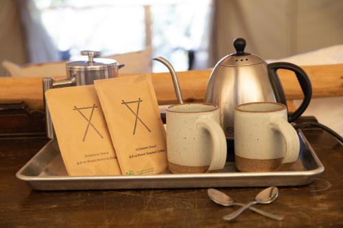 a tray with three coffee mugs and a tea kettle at Collective Hill Country in Wimberley