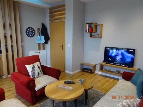 a living room with two chairs and a table and a tv at ORA-PRN,cosy apartment in the city center in Pristina