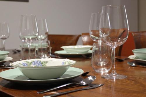 uma mesa de madeira com uma taça e copos de vinho em Casa Rialto em Olivenza