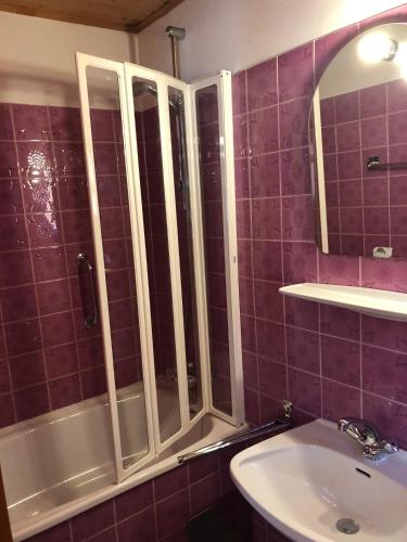 a bathroom with a tub and a sink and a mirror at Pension Reiterhaus in Wagrain