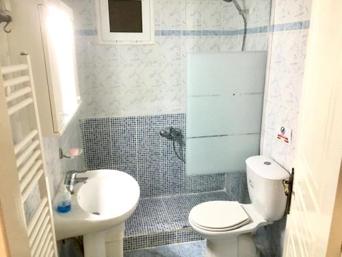 ein kleines Bad mit WC und Waschbecken in der Unterkunft Apartment near airport and beach in Artemida