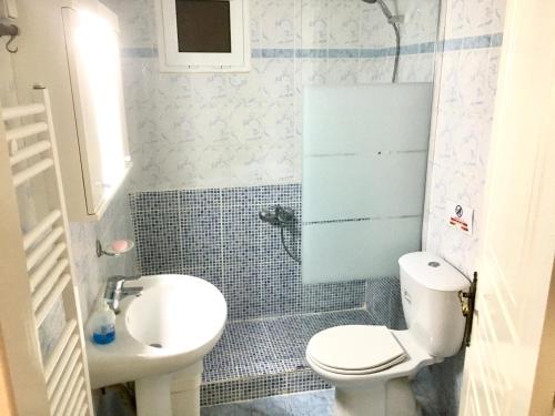 a small bathroom with a toilet and a sink at Apartment near airport and beach in Artemida