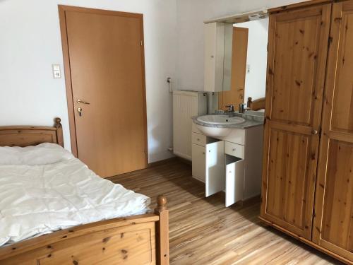 Schlafzimmer mit einem Bett, einem Waschbecken und einem Spiegel in der Unterkunft Pension Reiterhaus in Wagrain