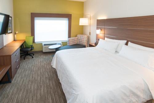 a hotel room with a large bed and a flat screen tv at Holiday Inn Express & Suites - North Battleford by IHG in North Battleford
