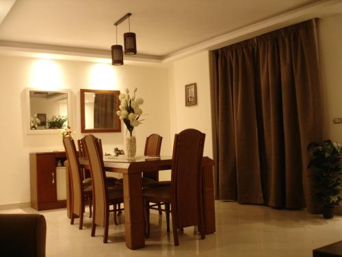 una mesa de comedor con sillas y un jarrón de flores en Luxury Furnished Apartment, en El Cairo