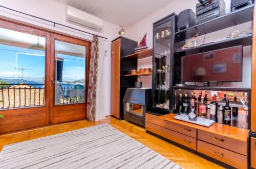 a room with a television and a counter with alcohol bottles at Apartment Buksa in Trogir