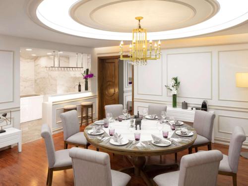a dining room with a table and chairs and a chandelier at Mercure Hai Phong in Hai Phong