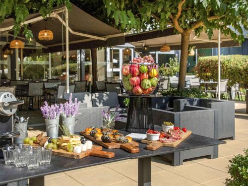 a table with fruits and vegetables on top at Mercure Cavaillon in Cavaillon