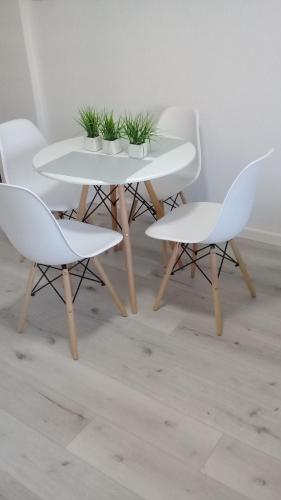 una mesa blanca y dos sillas con plantas. en MONOAMBIENTE LA PLATA - CENTRO en La Plata