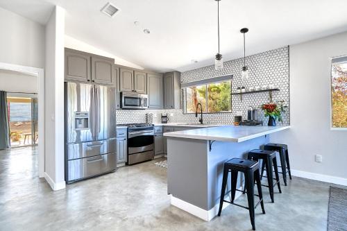 a kitchen with white cabinets and a large island with bar stools at Eclectic Joshua Tree in Joshua Tree