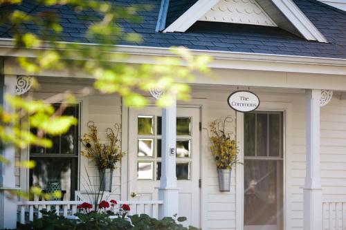 a white house with flowers on the front door at Eagle Harbor Inn in Ephraim