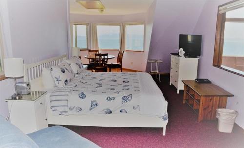 a bedroom with a bed and a table and a television at Driftwood Inn in Homer