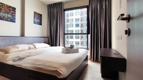 パタヤ・セントラルにあるパタヤ ビーチ シー ビュー ルーフトップ プール リゾートの大きなベッドと大きな窓のある寝室