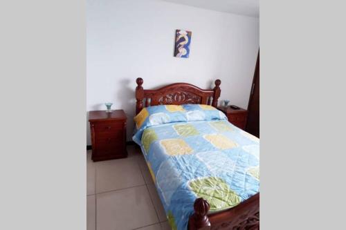 a bedroom with a bed with a blue and yellow quilt at Hermoso y acogedor apartamento en Belén Rodeo Alto in Medellín