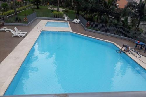 a man in a swimming pool at a hotel at Hermoso y acogedor apartamento en Belén Rodeo Alto in Medellín