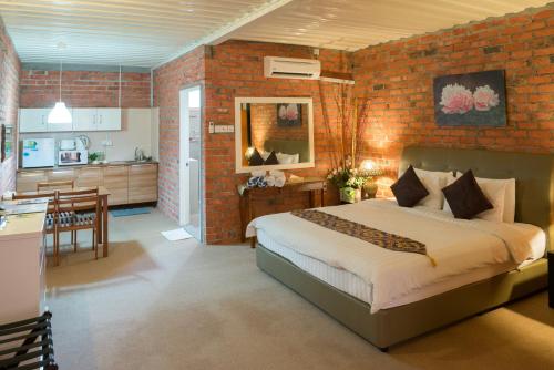 een slaapkamer met een bed en een bakstenen muur bij The Ocean Residence Langkawi in Kuah