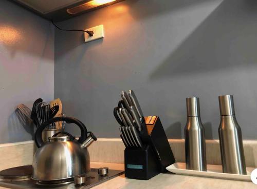 a tea kettle on a stove next to some knives at Modern Place of Style in Manila