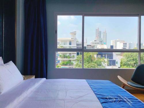a bedroom with a bed and a large window at Sapphire hotel Silom Bangkok in Bangkok