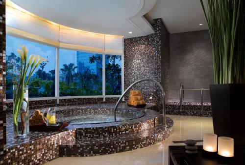 a bathroom with a jacuzzi tub with a large window at The Residences of The Ritz-Carlton Jakarta Pacific Place in Jakarta