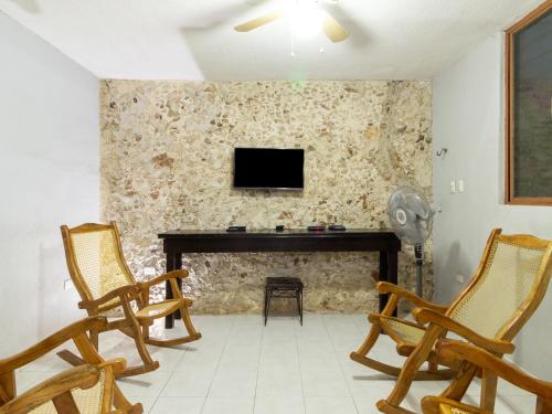 a living room with two chairs and a fireplace at Hotel Aventura in Mérida