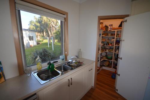 a kitchen with a sink and a window at Seascape Beach House in Boat Harbour