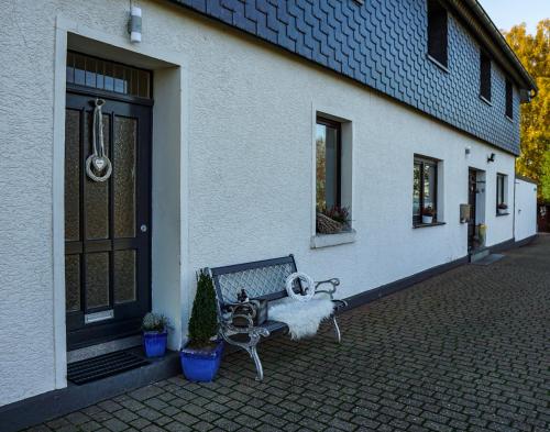 a bench sitting outside of a building with a door at Ferienapartment Christine in Simmerath