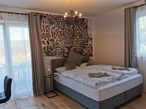 1 dormitorio con 1 cama con una pintura de 2 tigres en Enjoyit Velden West, en Selpritsch
