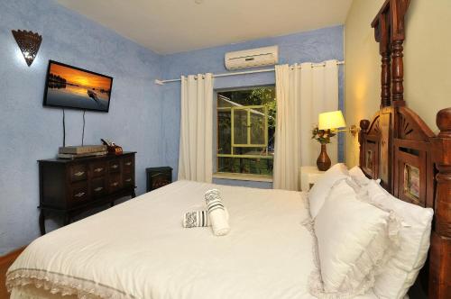 a bedroom with a large white bed and a window at Love & Lemons in Yesod Hamaala