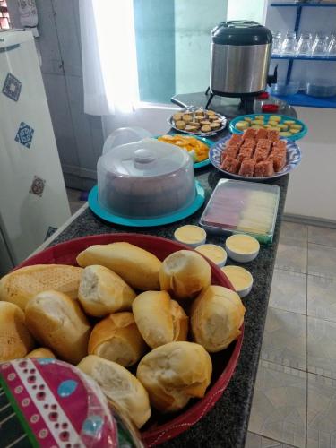 einen Tisch mit Platten aus Brot und Gebäck in der Unterkunft Mundo da Lua Hostel in Morro de São Paulo