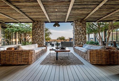 a patio with couches and a table on a deck at Kruger Sunset Lodge in Hectorspruit