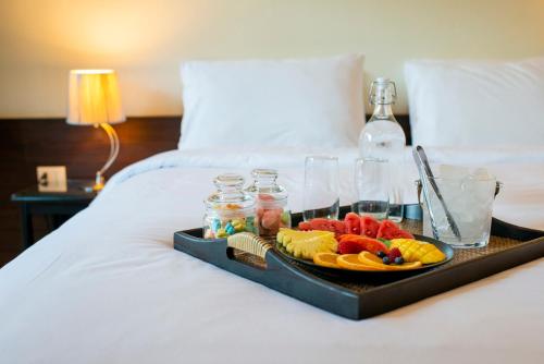 a tray of fruit and drinks on a bed at Lokal Phuket "Former K-Hotel" - SHA Extra Plus in Patong Beach