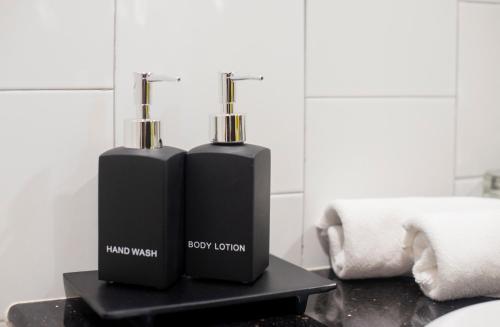 two black bottles sitting on a black table in a bathroom at Lokal Phuket "Former K-Hotel" - SHA Extra Plus in Patong Beach