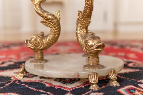 a pair of gold peacock candlesticks on a rug at Apartments - Laipu in Rīga