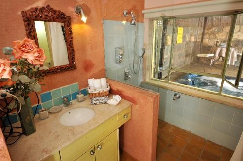 La salle de bains est pourvue d'un lavabo et d'un miroir. dans l'établissement Love & Lemons, à Yessud Haméala