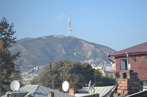 a mountain with a tower on top of it at Your House In Tbilisi in Tbilisi City