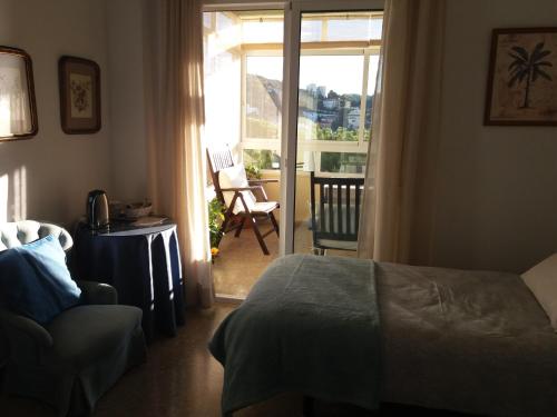 1 dormitorio con 1 cama y puerta que da a un patio en Double room with brekfast "Wonderful views" en Málaga
