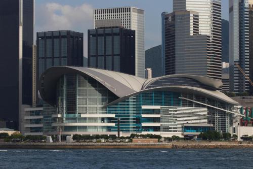 a large building with a curved roof in front of a city at Kew Green Hotel Wanchai Hong Kong in Hong Kong