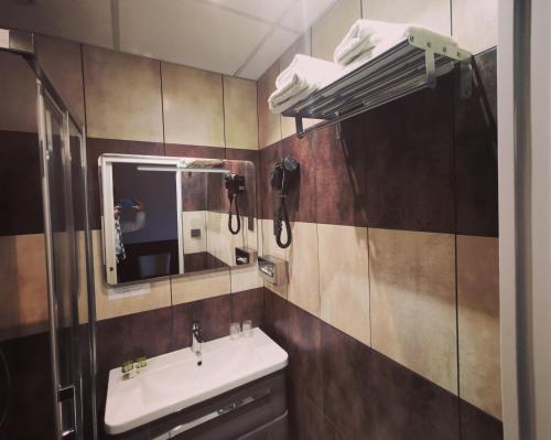 a bathroom with a sink and a mirror at Logis Hotel Des Bains in Gérardmer