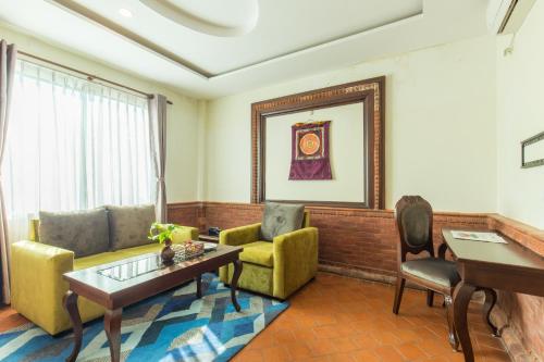 a living room with a couch and a table and chairs at Dahlia Boutique Hotel in Pokhara
