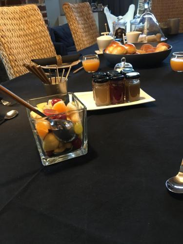 a black table with a tray of fruit and jams at Au Calme de Hosdent in Braives