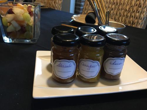 a white plate with five jars of jam on a table at Au Calme de Hosdent in Braives